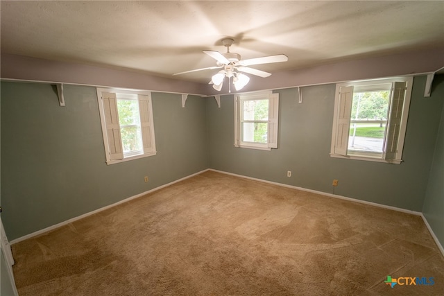 spare room with ceiling fan, a healthy amount of sunlight, and carpet floors