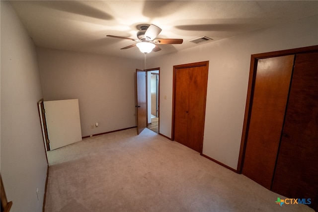 unfurnished bedroom featuring light carpet and ceiling fan