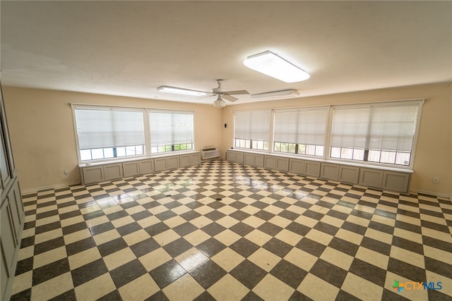 interior space featuring an AC wall unit and ceiling fan