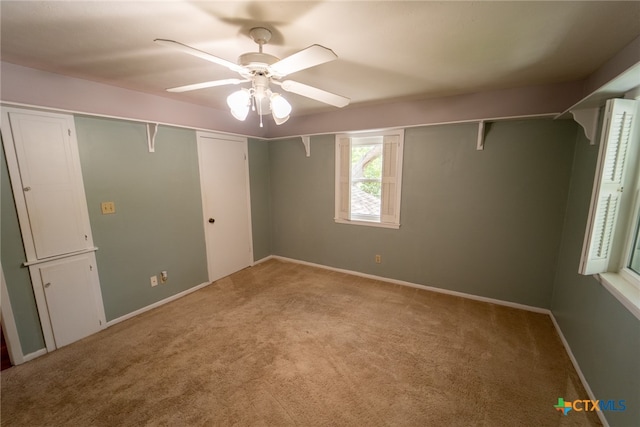 unfurnished bedroom featuring ceiling fan, light carpet, and a closet