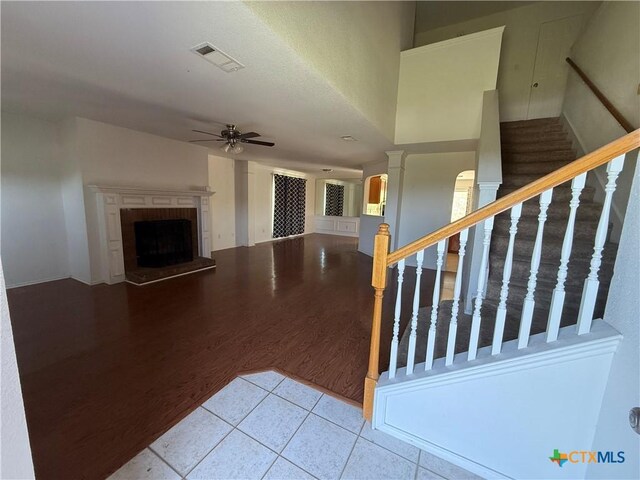 3054 Colorado Dr, Copperas Cove, TX 76522 - unfurnished living room with ceiling fan, wood finished floors, a fireplace with raised hearth, and stairs