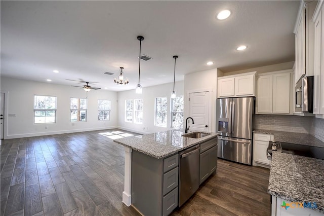 kitchen featuring a center island with sink, ceiling fan with notable chandelier, sink, white cabinetry, and stainless steel appliances