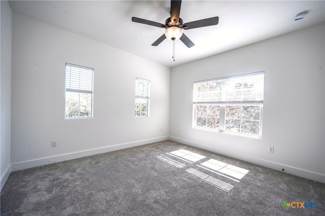 carpeted empty room with ceiling fan and plenty of natural light