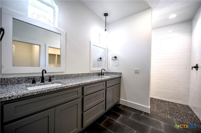 bathroom featuring tiled shower and vanity