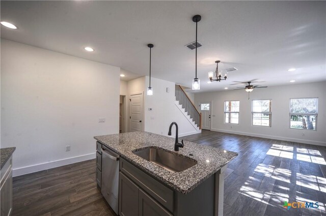 kitchen featuring dishwasher, sink, hanging light fixtures, a center island with sink, and ceiling fan with notable chandelier