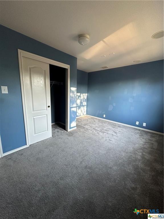 unfurnished bedroom featuring baseboards, a closet, and carpet floors