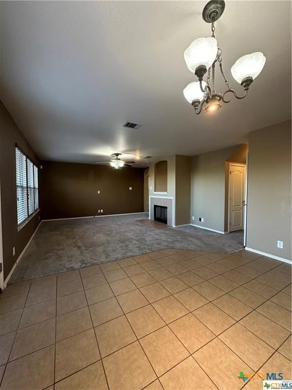 unfurnished living room with light carpet, baseboards, visible vents, and a tile fireplace