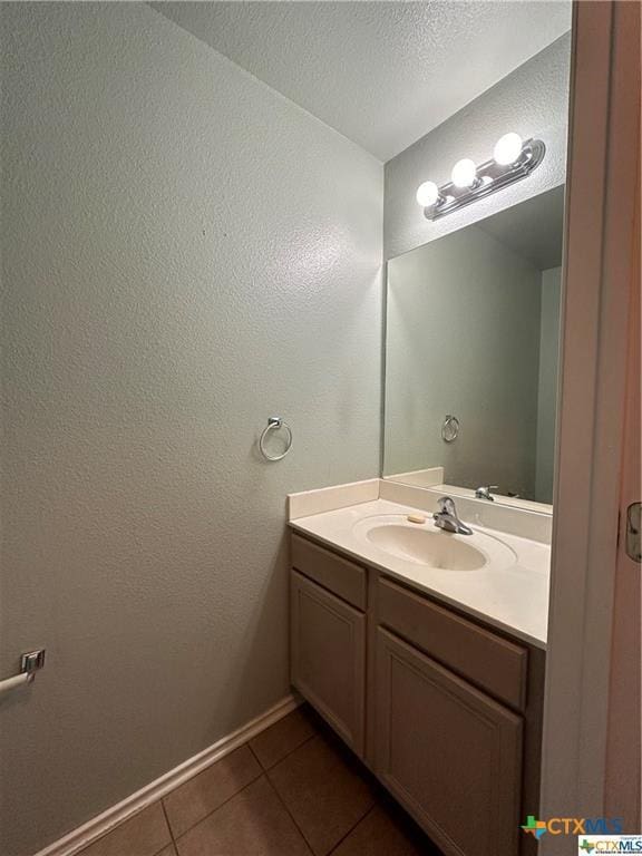 bathroom with baseboards, tile patterned flooring, and vanity