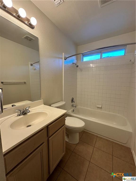 full bathroom featuring toilet, shower / bathtub combination, vanity, visible vents, and tile patterned flooring