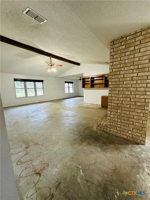 unfurnished living room with lofted ceiling with beams, concrete flooring, and a textured ceiling