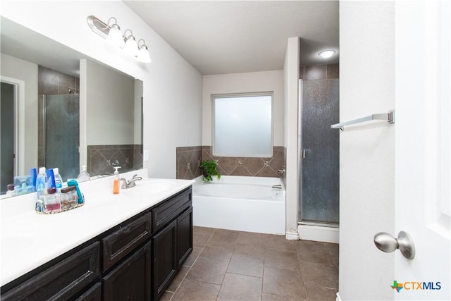 full bath featuring a garden tub, vanity, tile patterned flooring, and a shower stall