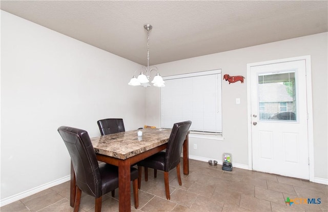 dining space with baseboards, tile patterned floors, and a chandelier
