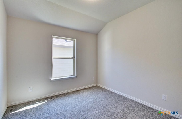 unfurnished room with carpet and vaulted ceiling