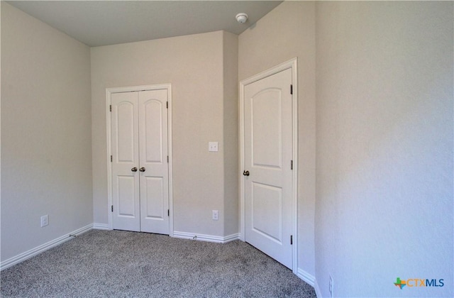 unfurnished bedroom featuring light carpet and a closet