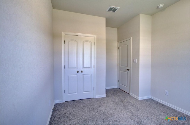 unfurnished bedroom featuring light colored carpet and a closet