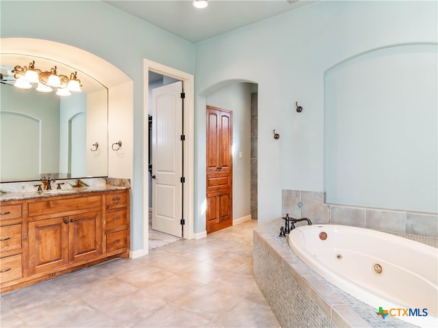 bathroom with vanity, tile patterned flooring, and tiled tub