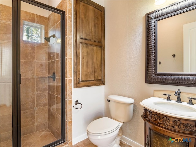 bathroom featuring toilet, vanity, and a shower with shower door