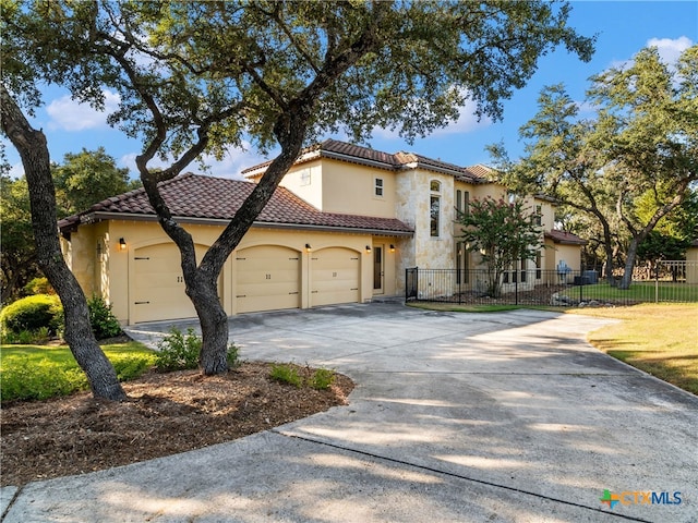 mediterranean / spanish house featuring a front lawn and a garage