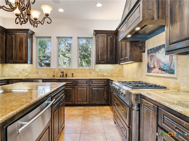 kitchen with dark brown cabinets, tasteful backsplash, and light stone countertops