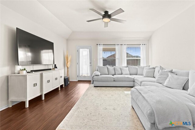 living room with ceiling fan, vaulted ceiling, and dark hardwood / wood-style floors