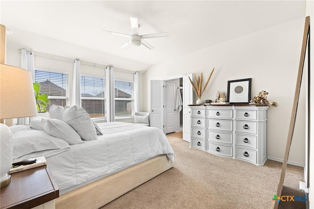 bedroom featuring ceiling fan, vaulted ceiling, and light colored carpet