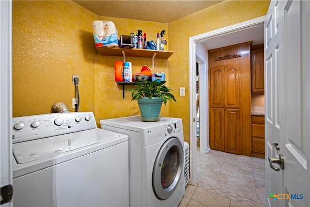 103 River Mdw, Castroville, TX 78009 - laundry area featuring washing machine and clothes dryer, light tile patterned floors, and a textured wall