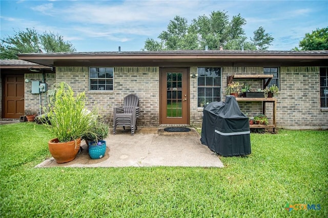 1617 Avalon St, Port Lavaca, TX 77979 - rear view of house featuring a yard, a patio, and brick siding