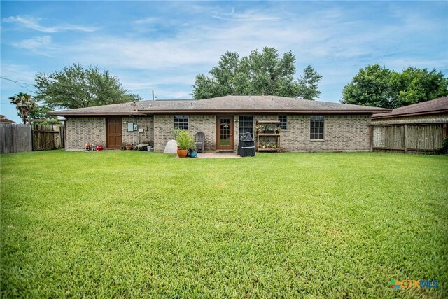 1617 Avalon St, Port Lavaca, TX 77979 - back of property with a fenced backyard and brick siding