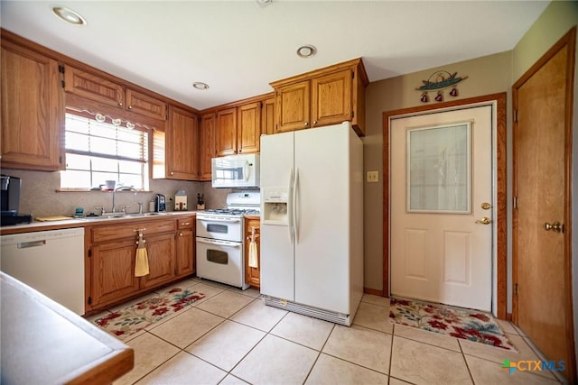 1617 Avalon St, Port Lavaca, TX 77979 - kitchen with white appliances, brown cabinetry, decorative backsplash, light countertops, and light tile patterned floors