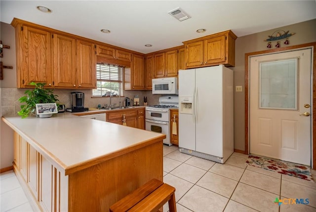 1617 Avalon St, Port Lavaca, TX 77979 - kitchen with white appliances, light countertops, a peninsula, tasteful backsplash, and recessed lighting