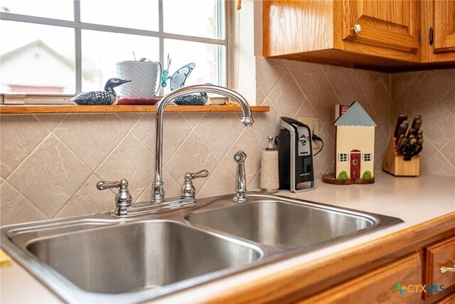 1617 Avalon St, Port Lavaca, TX 77979 - kitchen view of brown cabinetry, tasteful backsplash, light countertops, and pot filler