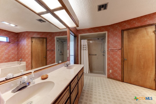 bathroom with vanity, a textured ceiling, and plus walk in shower