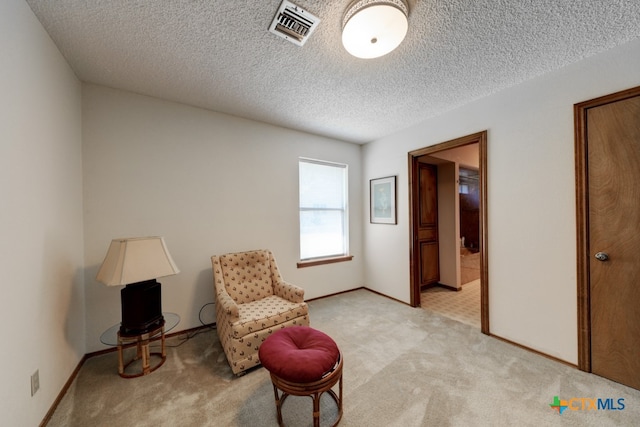 living area featuring a textured ceiling and light carpet