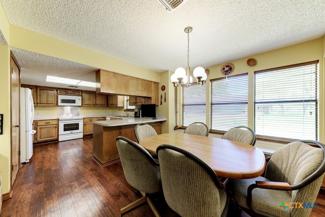 dining space with dark hardwood / wood-style floors, a textured ceiling, a chandelier, and sink