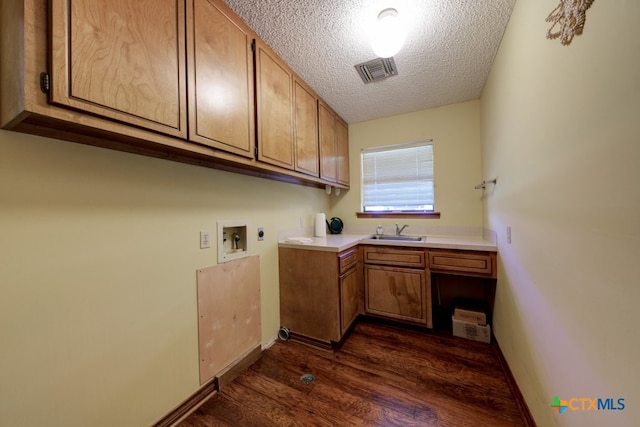 laundry room featuring hookup for a washing machine, a textured ceiling, cabinets, sink, and dark wood-type flooring