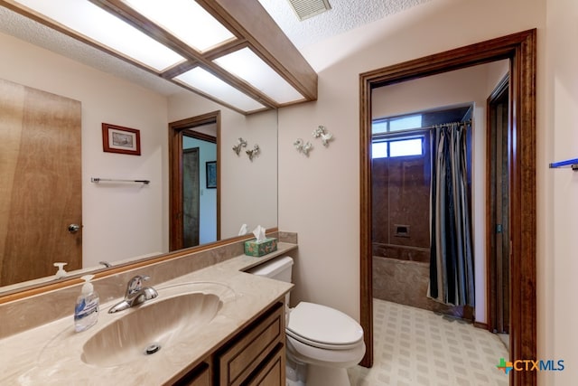 bathroom featuring vanity, a textured ceiling, and toilet