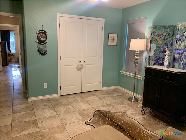 interior space featuring baseboards and light tile patterned flooring