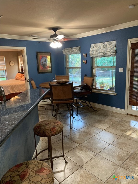 dining space with light tile patterned floors, baseboards, ornamental molding, and a ceiling fan