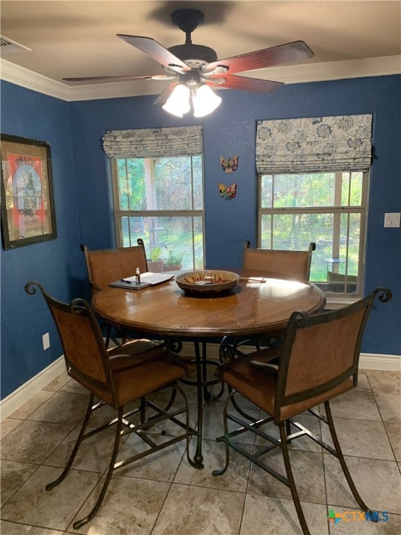 dining room with light tile patterned floors, plenty of natural light, ornamental molding, and baseboards