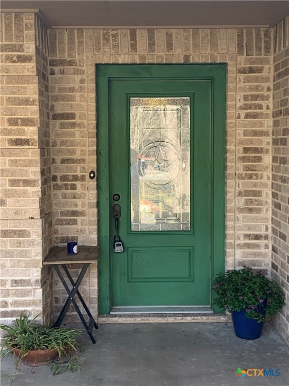 property entrance featuring brick siding