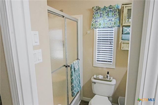 bathroom featuring walk in shower and toilet