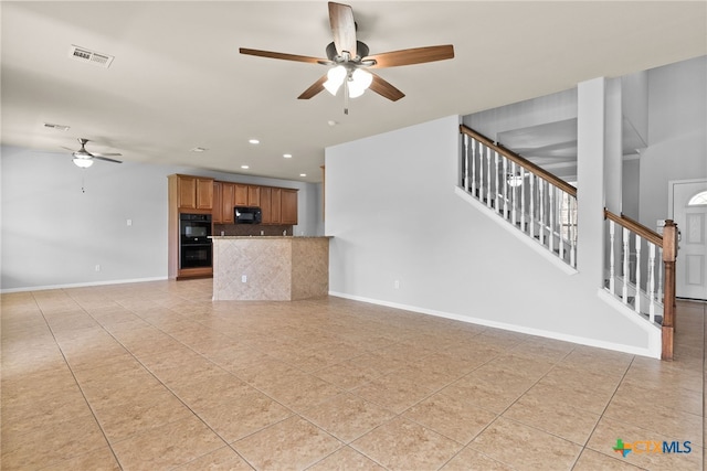 unfurnished living room with ceiling fan and light tile patterned floors