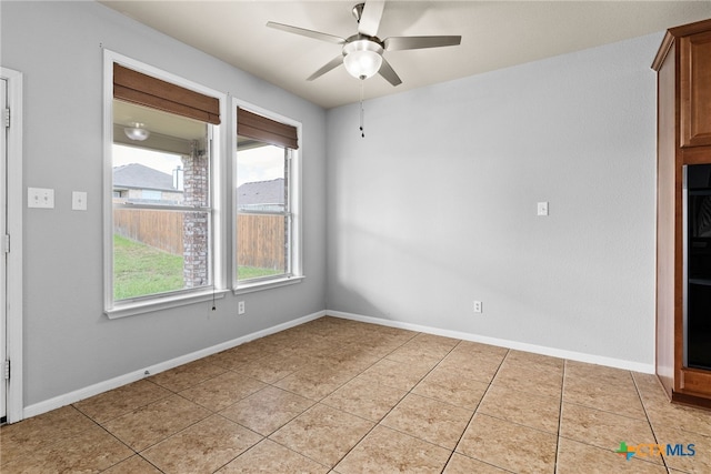 tiled spare room featuring ceiling fan