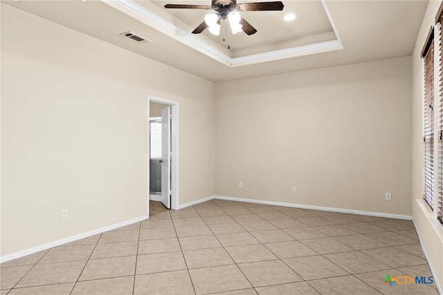 spare room featuring light tile patterned floors, a tray ceiling, and ceiling fan