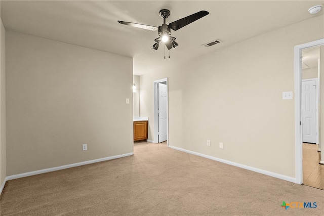 spare room featuring ceiling fan and light colored carpet