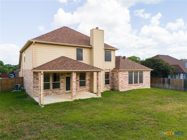 back of property with a yard, central AC unit, and a patio area