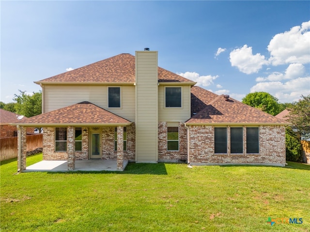 rear view of house with a lawn and a patio area