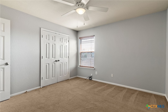 unfurnished bedroom with carpet flooring, ceiling fan, and a closet