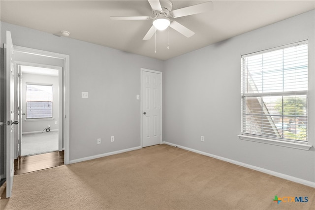 unfurnished bedroom with multiple windows, ceiling fan, and carpet