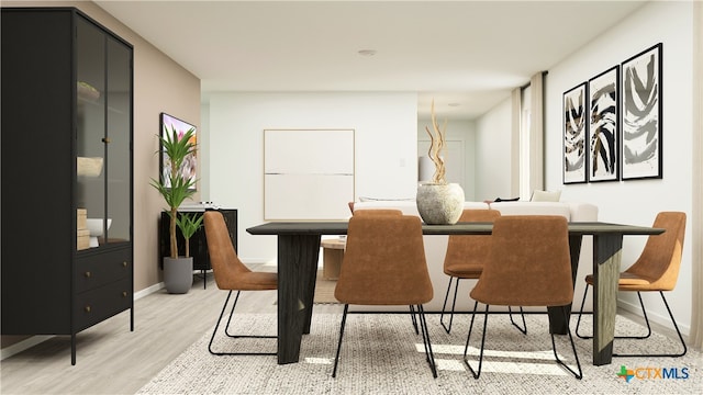 dining room featuring baseboards and light wood-type flooring